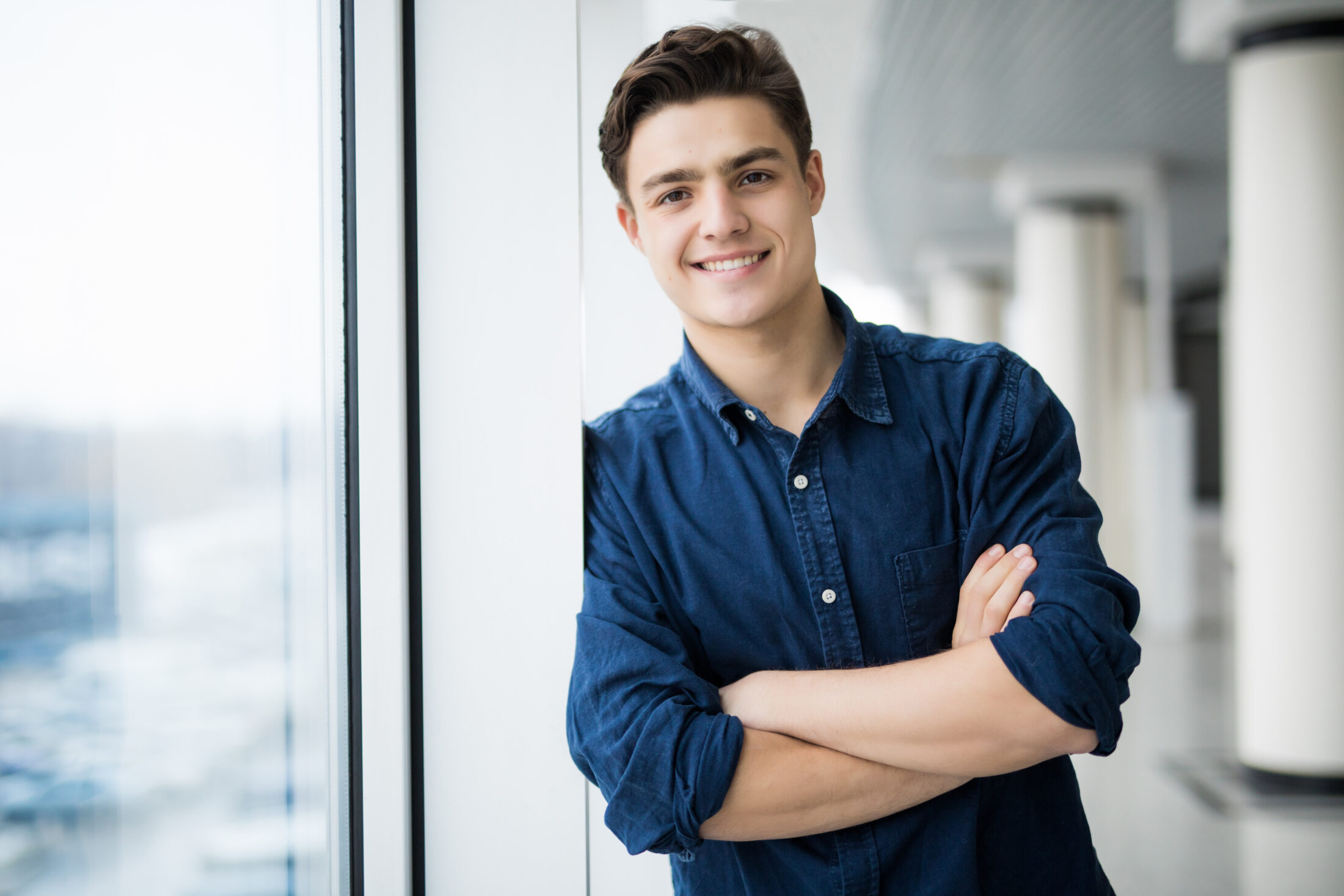 A young man leaning against a window